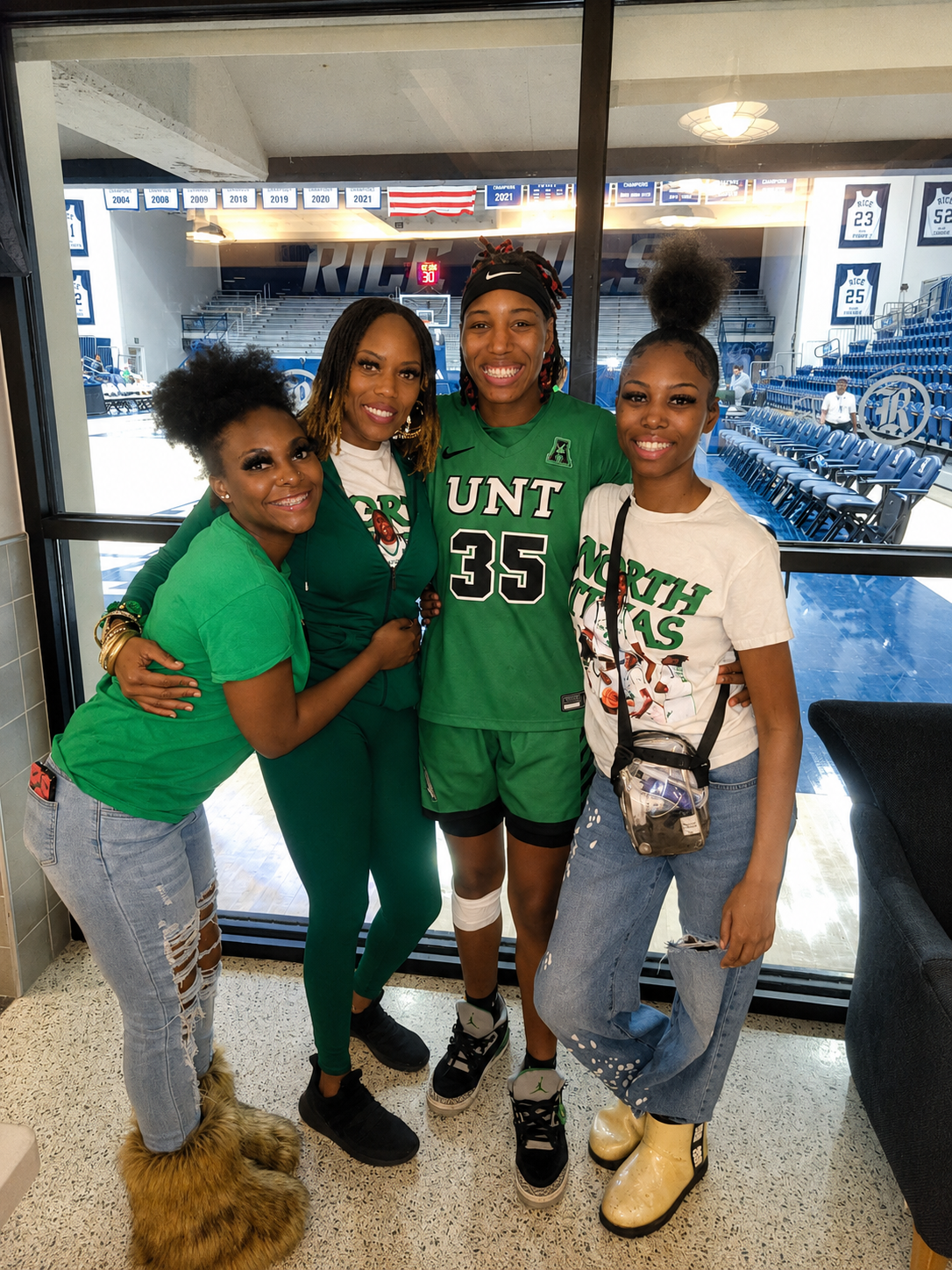 Founder of Peculiarity Footwear posing with her three daughters at a basketball arena, representing confidence, family, and stylish women with larger shoe sizes.