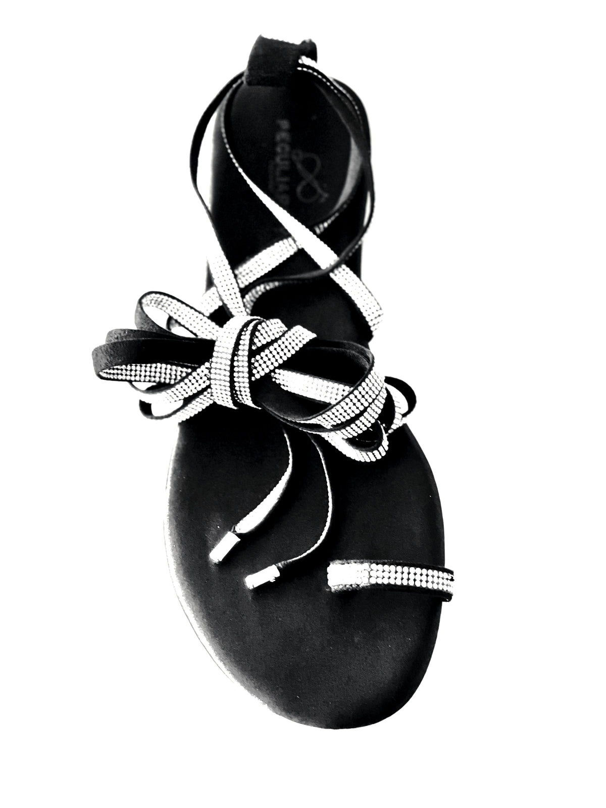 Black sandal with decorative straps on a white background