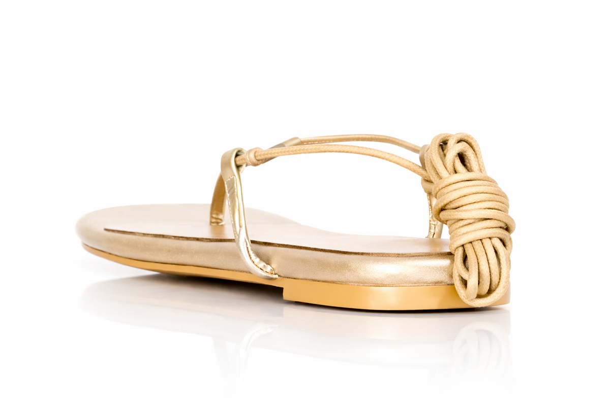 Gold sandal with rope design on a white background