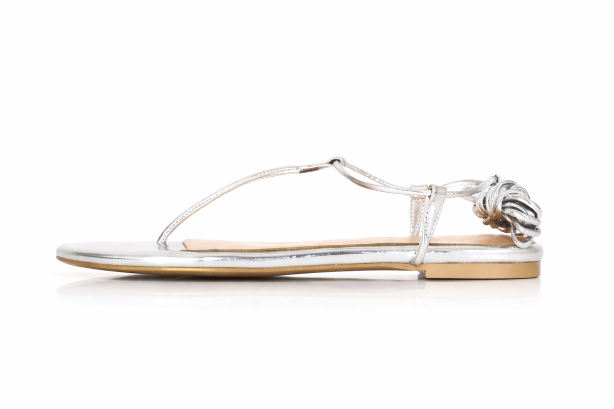 Silver sandal with knotted laces on a white background. Size 12.